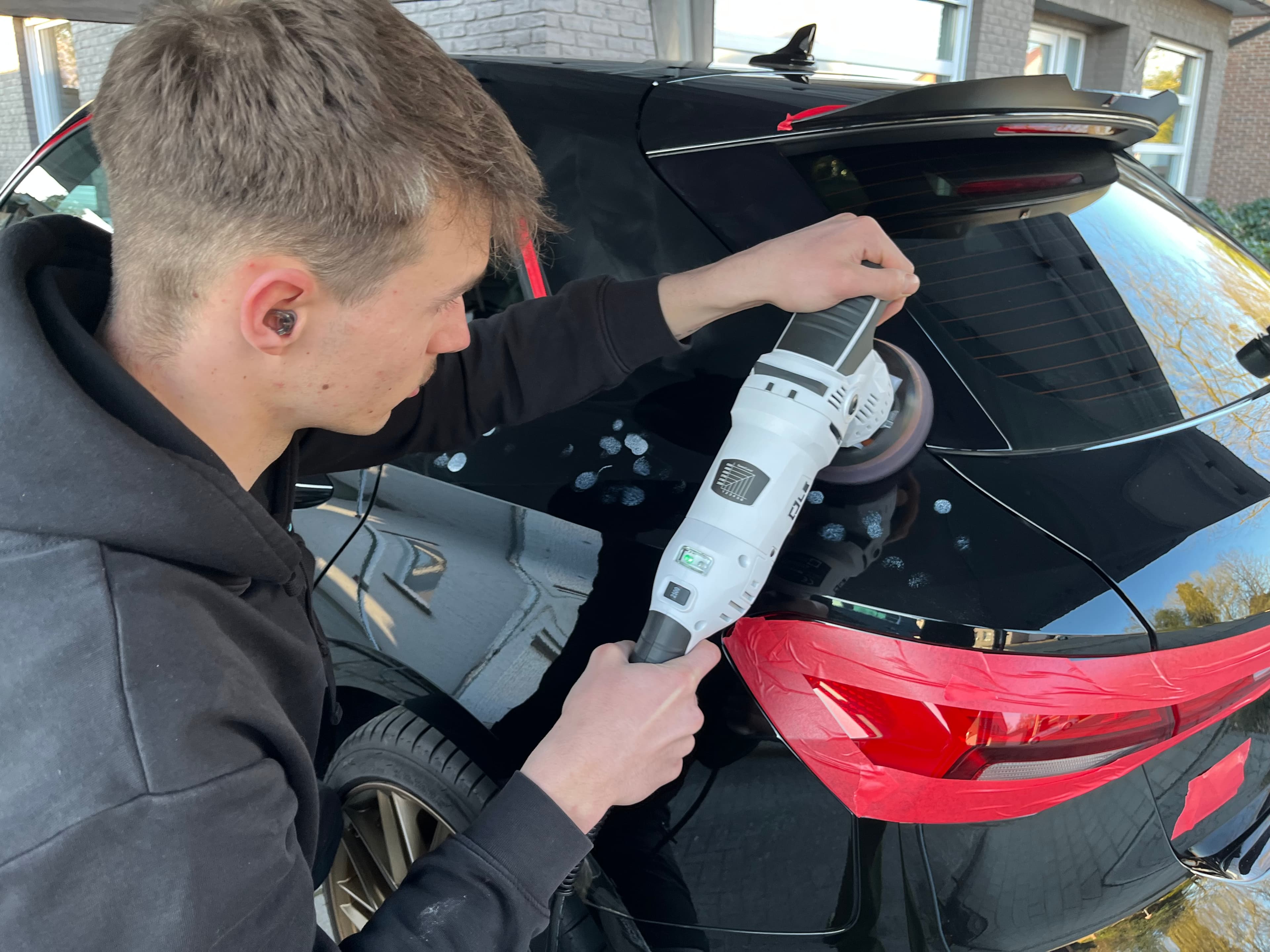 Arno Jansen aan het werk op een zwarte wagen